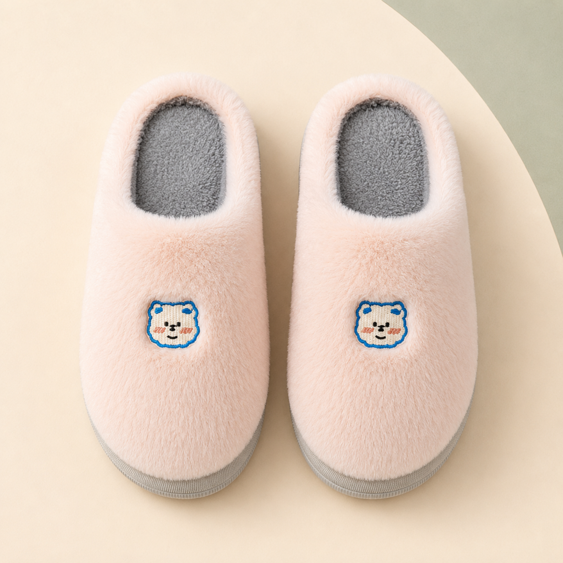 Overhead view of Blush Lumi slippers showing the rounded plush uppers, bear embroidery and grey cotton footbeds.