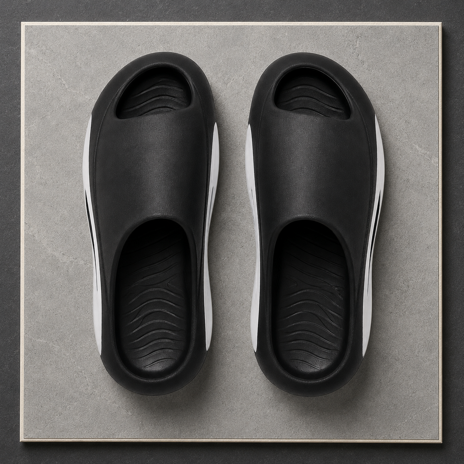 Overhead view of black and white Soren EVA slides showing the peep toe and contoured footbeds.