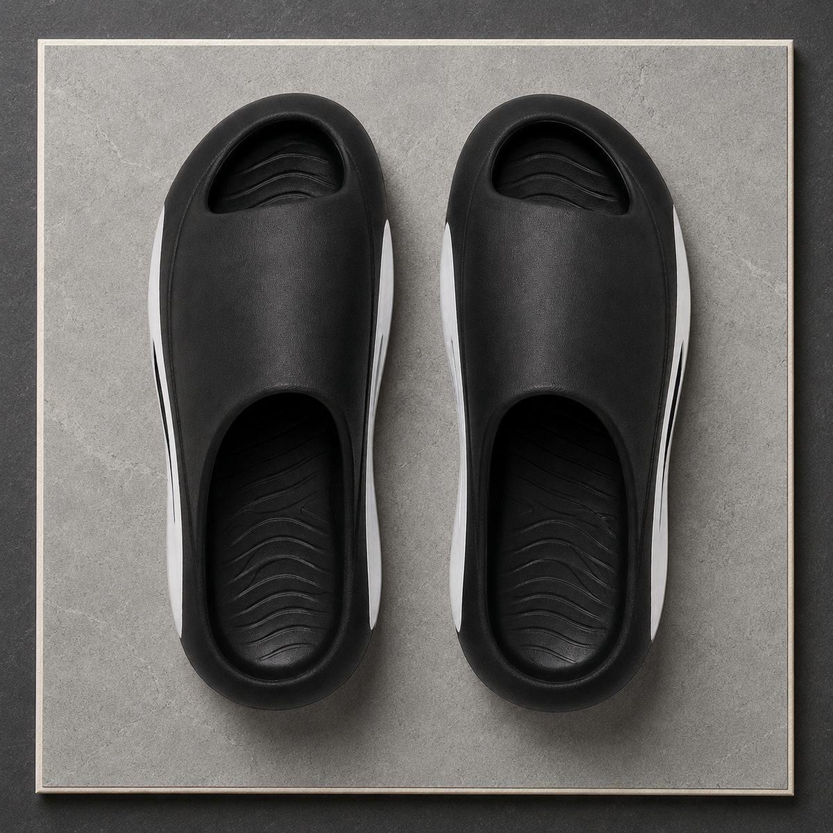 Overhead view of black and white Soren EVA slides showing the peep toe and contoured footbeds.