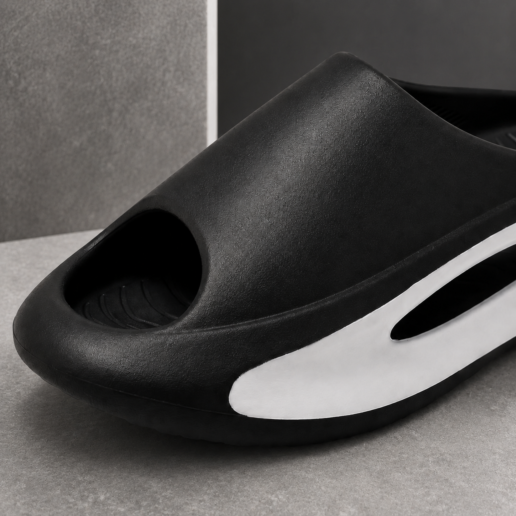 Close view of the matte black EVA texture, peep-toe edge, white insert and oval side window.